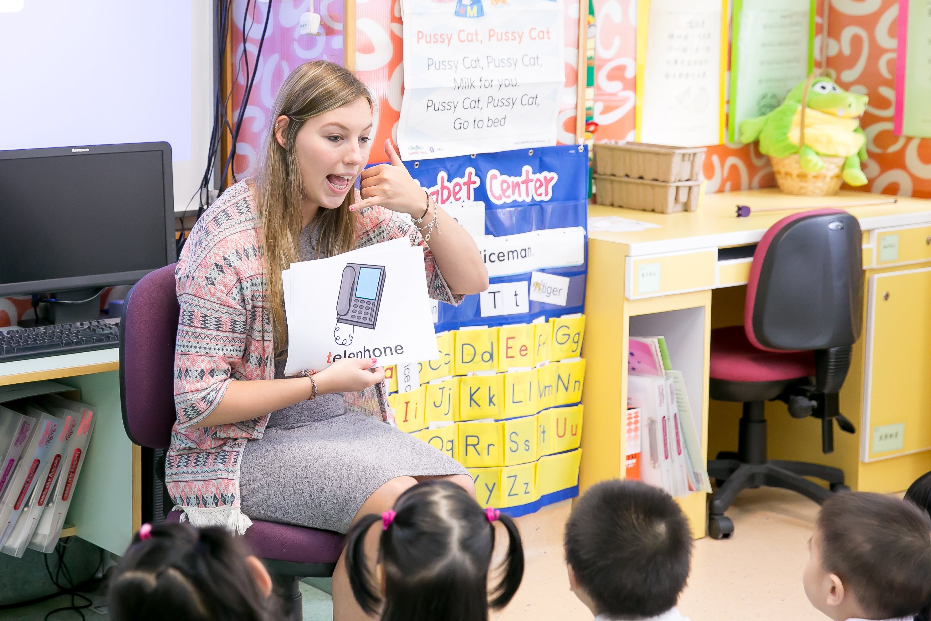 a TEFL teacher is explaining a telephone flashcard to chinese children